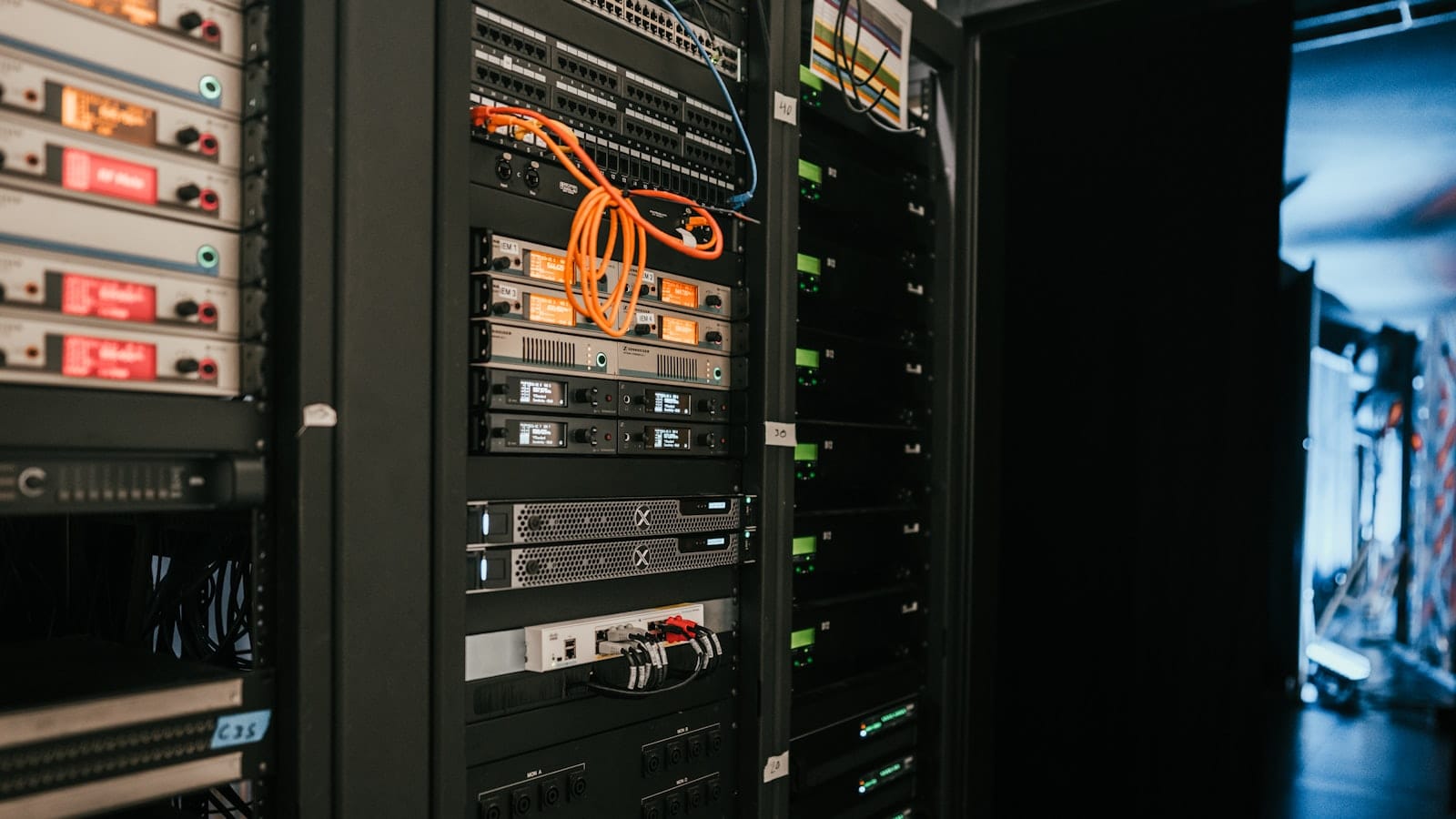 Rows of server racks in a data center, with cabling and status lights